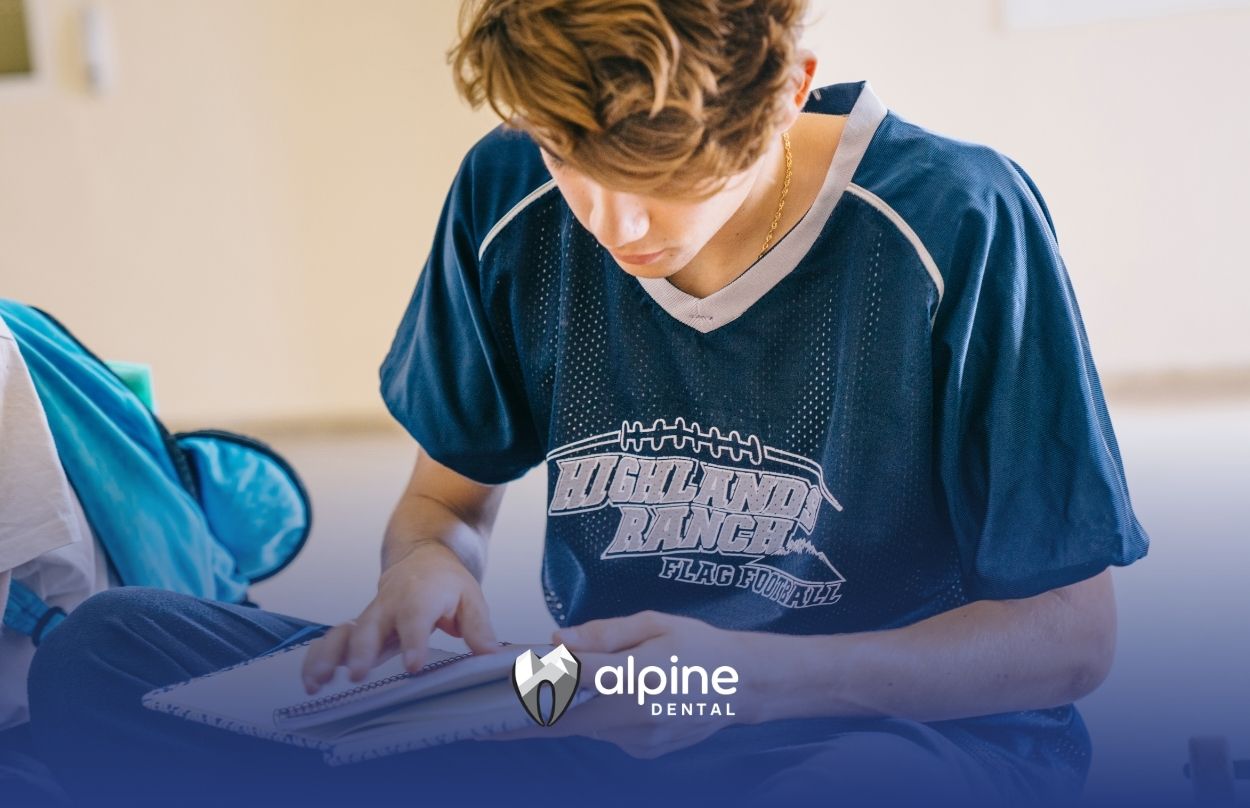Teen athlete with notebook and sports gear prepares for school, fall activities, and thoughtful dental care planning.