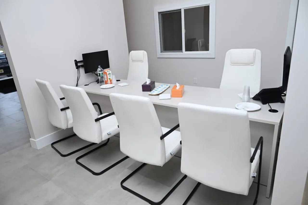 Meeting room with a long table and white chairs at Alpine Dental in Jackson, NJ