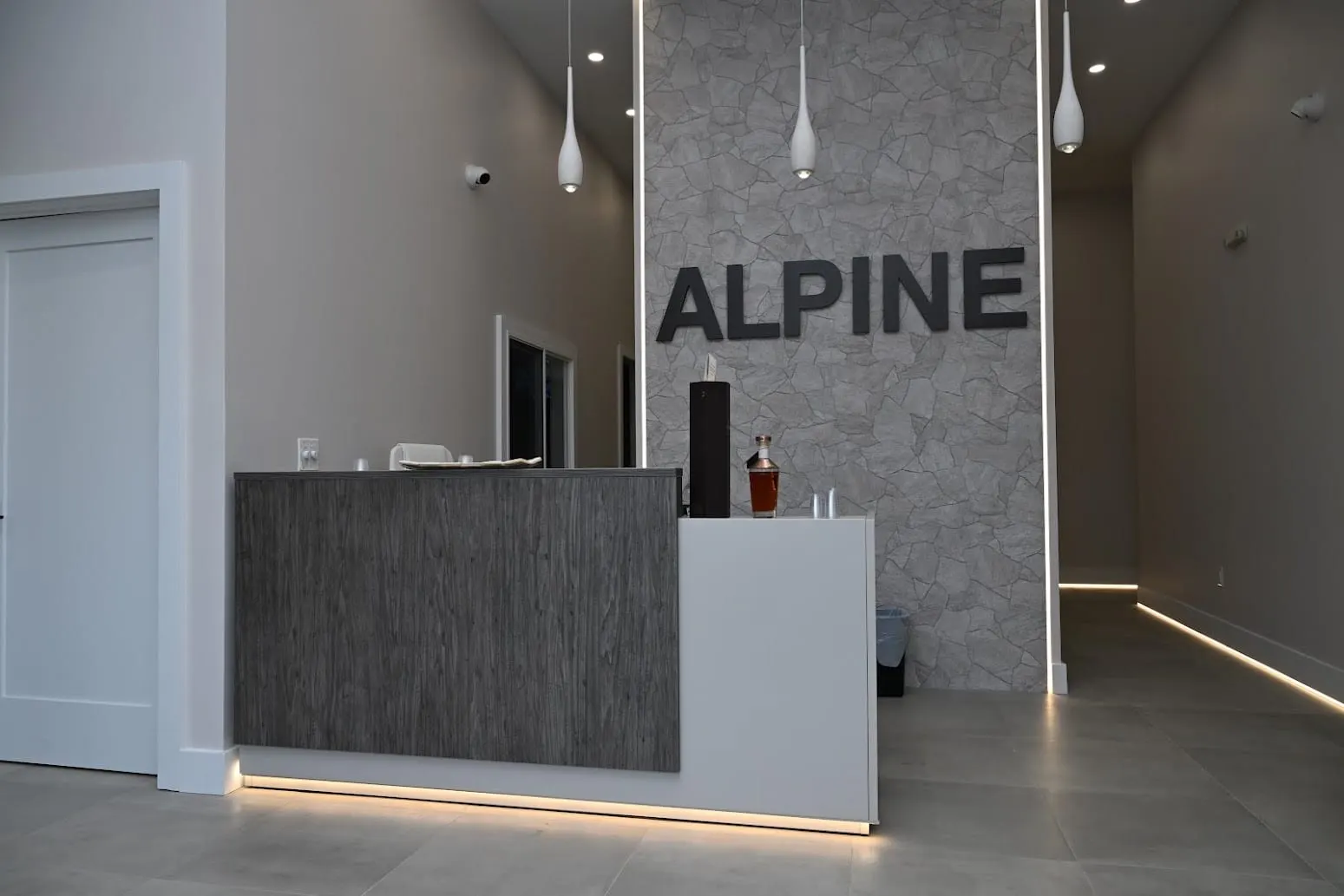 Reception desk and stone feature wall with the Alpine sign at the Jackson, NJ dental office